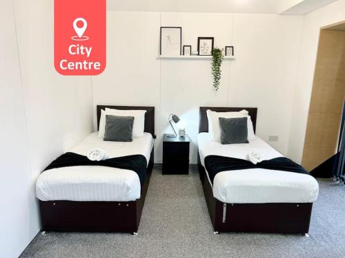 two beds in a room with a sign that says city centre at Large Townhouse 5 Beds with Two Parking Spaces - Manchester City Centre in Manchester