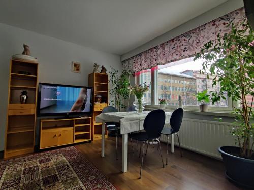 a dining room with a table and a tv at City Home Lahti in Lahti