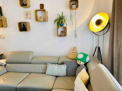 un salon avec un canapé gris avec un jouet dans l'établissement 3' Subway, 15' Center, AC, Parking, Calm, Balcony, aux Lilas