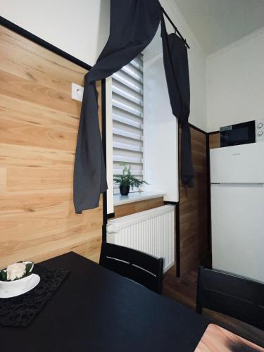 a dining room with a black table and a window at Mázli Vendégház in Sátoraljaújhely