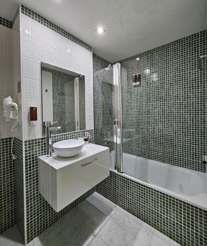 a bathroom with a sink and a bath tub at Apartamento Vilallonga in Figueres