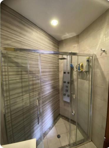 eine Dusche mit einer Glastür in einem Badezimmer in der Unterkunft Room's Service Swieqi in Tal-Għoqod