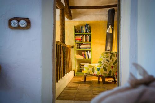 a hallway with a chair and a book shelf at Casa Rural La Alameda in Madridejos