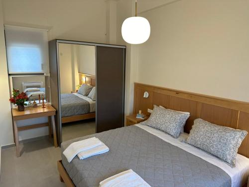 ein Schlafzimmer mit einem großen Spiegel und einem Bett in der Unterkunft Mitos Villas in Gerani Chania