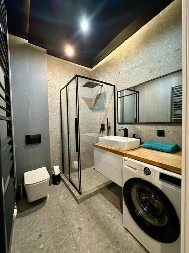a bathroom with a washing machine and a toilet at Apartament Kaszubska Bryza in Hel