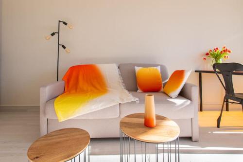 un salon avec un canapé et deux tables dans l'établissement Cap sur le sud * Vue Mer * Clim * Parking * wifi * Couchant *, à La Grande Motte