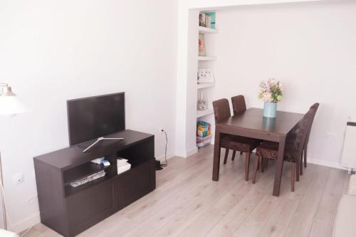 a dining room with a table and a television at La morada del viajero in Granada