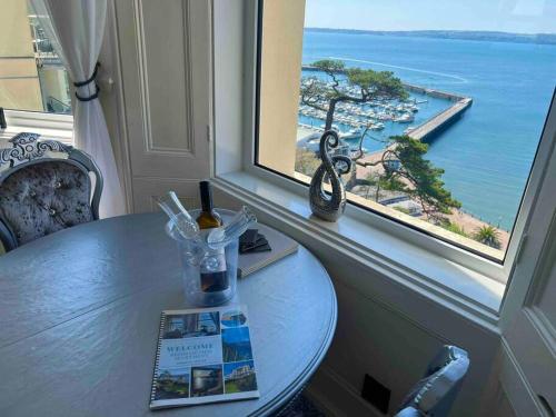 a table with a window with a view of the ocean at Waterside & Marina View Apartment in Torquay in Torquay