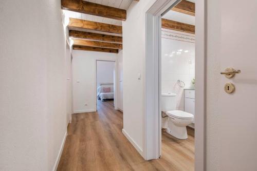 La salle de bains blanche est pourvue de toilettes et d'un lavabo. dans l'établissement CARCAVELOS CHALLET, à Carcavelos