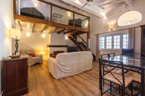 ein Wohnzimmer mit einem Loft mit einer Treppe in der Unterkunft CARCAVELOS CHALLET in Carcavelos