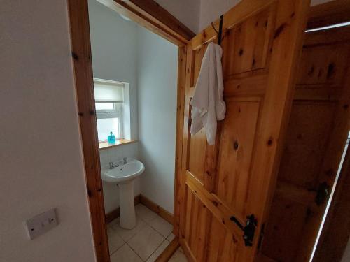 3 bed semi-detached house in a quite estate في Bruff: حمام مع مرحاض وباب خشبي