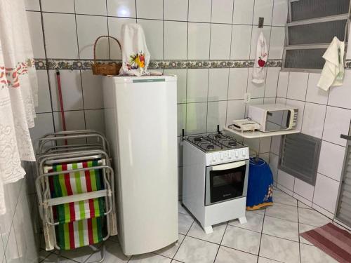 eine kleine Küche mit einem Herd und einer Mikrowelle in der Unterkunft Apartamento a 4 min a pé da Praia das Castanheiras in Guarapari