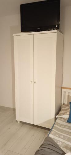 a white cabinet with a television on top of it at Agroturystyka U Baltazara in Duszniki Zdrój