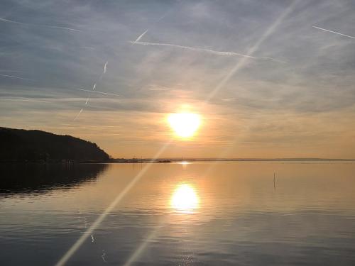 a sun setting over a body of water at Ház a szígeten in Fonyód