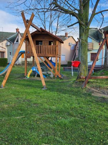 a park with a playground with a tree at Ház a szígeten in Fonyód