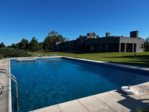 a large swimming pool in front of a house at Casa de campo en Capilla del Señor in Capilla del Señor