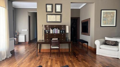 a living room with a desk and a white couch at Casa de campo en Capilla del Señor in Capilla del Señor