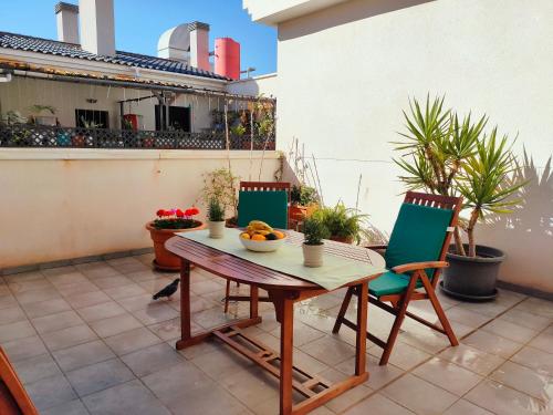 Un patio con una mesa y sillas en un balcón. en Ático - Piscina Málaga centro, en Málaga
