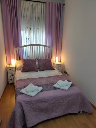 a bedroom with a bed with two towels on it at Ático - Piscina Málaga centro in Málaga