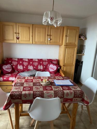une table à manger avec des chaises et un canapé rouge dans l'établissement APPARTEMENT MONTAGNE, à Thollon-les-Mémises