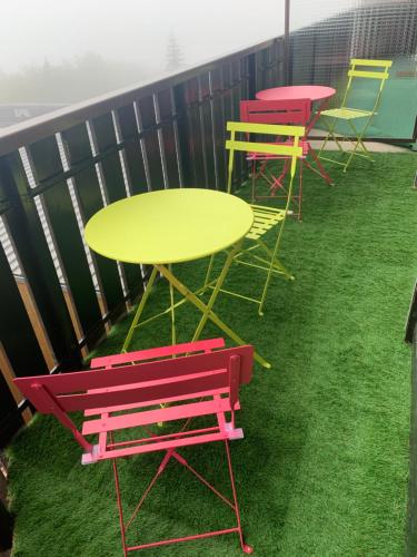 une rangée de tables et de chaises colorées sur un balcon dans l'établissement APPARTEMENT MONTAGNE, à Thollon-les-Mémises
