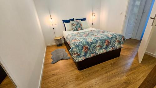 a small bedroom with a bed and a wooden floor at A m a r - 450m from the beach in São Roque