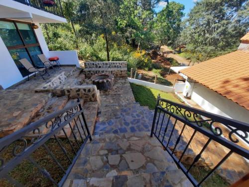um quintal com um pátio de pedra e uma cerca em El Roble de los Abuelos Hotel de Montaña Colibri em Mazamitla