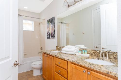 y baño con lavabo, aseo y espejo. en Top Villas - Encore Resort 1528, en Orlando