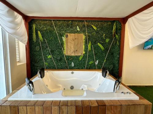 eine Badewanne in einem Zimmer mit grüner Wand in der Unterkunft Olmo Apartahotel in Pereira
