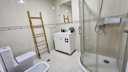 a bathroom with a shower and a toilet and a sink at A m a r - 450m from the beach in São Roque