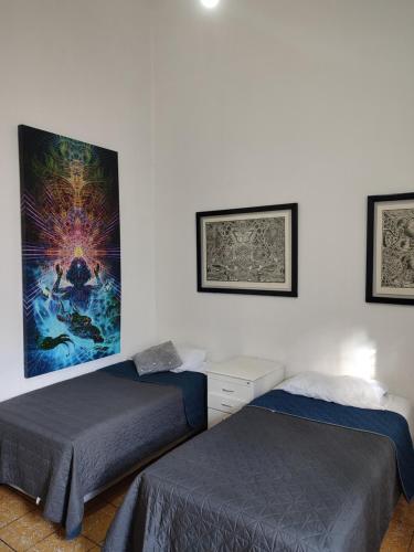 1 dormitorio con 2 camas y un cuadro en la pared en Hostal Centeno, en Guadalajara