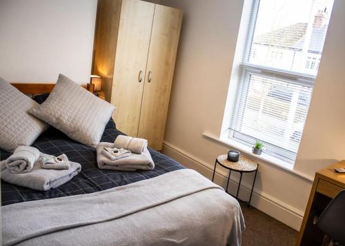 um quarto com uma cama com toalhas em Cosy Lodge for up to 9 guests near hart of Lincoln! Short let & longer bookings welcome, weekly and monthly offers em Lincolnshire