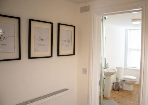 a bathroom with three framed pictures on the wall at Cosy Lodge for up to 9 guests near hart of Lincoln in Lincolnshire