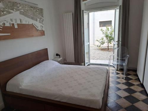 利沃諾的住宿－Davantialmare，一间卧室设有一张床,一扇门通往庭院