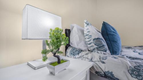 a plant on a white table next to a bed at Park Avenue - An Executive 2 Bed Suite with a Private Bathroom in Birmingham City Centre, 5 mins to City Hospital in Birmingham