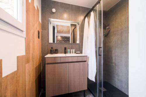een badkamer met een wastafel, een spiegel en een douche bij Le Black & White - 10 min Orly, 3 min gare Juvisy in Athis-Mons