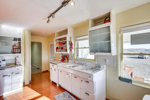 a kitchen with white cabinets and a sink and a window at Charming Farmington Home about 16 Mi to Aztec Ruins! in Farmington