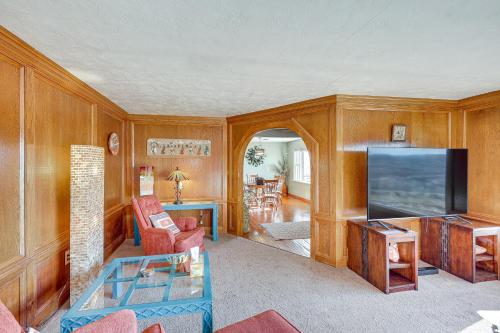 a living room with wooden walls and a flat screen tv at Charming Farmington Home about 16 Mi to Aztec Ruins! in Farmington