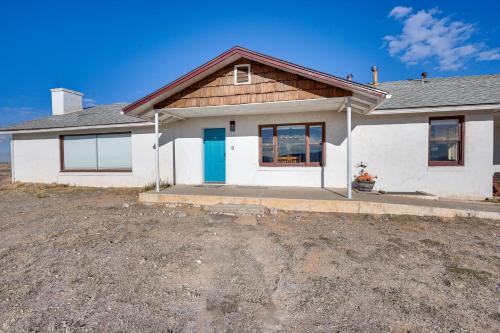a white house with a blue door at Charming Farmington Home about 16 Mi to Aztec Ruins! in Farmington