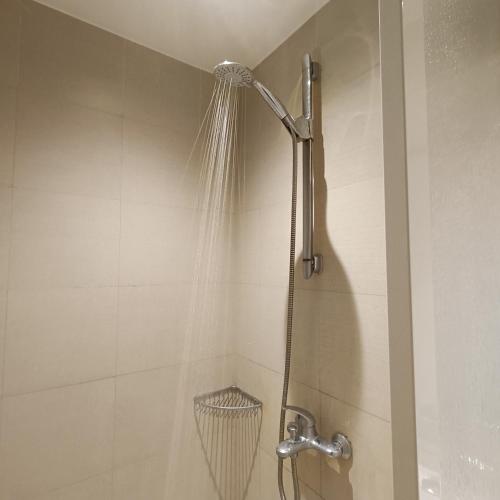 a shower with a shower head in a bathroom at 1-BR Vintage Condotel - Azure Resort in Manila