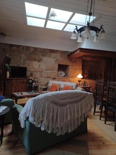 a bedroom with a bed and a stone wall at Casario do Vale Hospedagem e Eventos in Assento
