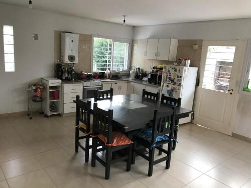 uma cozinha com uma mesa e cadeiras e um frigorífico em La Casita de DaniMar em Yerba Buena