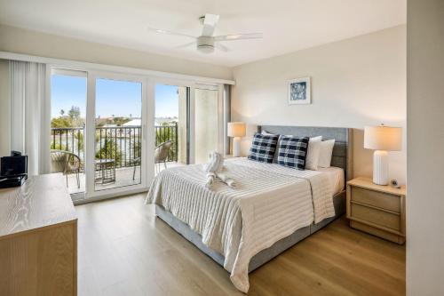 1 dormitorio con 1 cama y balcón en Land's End 1-406 Bay Front - Premier, en St Pete Beach