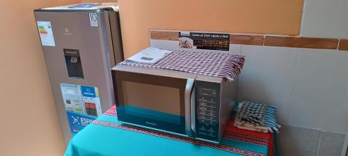 a microwave sitting on top of a pile of boxes at Hospedaje Vacacional - Colca in Chivay