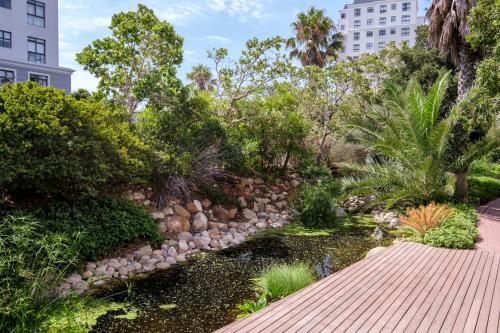 un jardín con una pasarela y un estanque en Belina - Mayfair Premier en Ciudad del Cabo