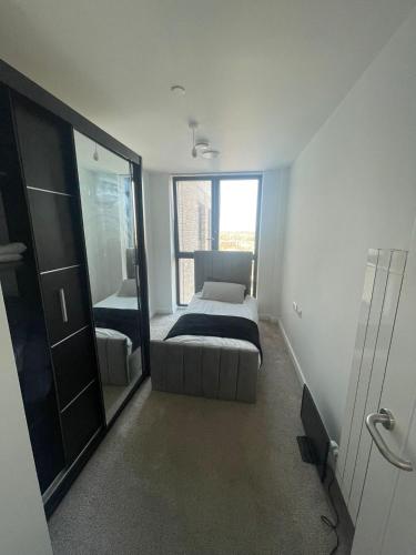 a bedroom with a bed and a large window at New Luxury 2 Bedroom apartment with a beautiful London City view in Barking