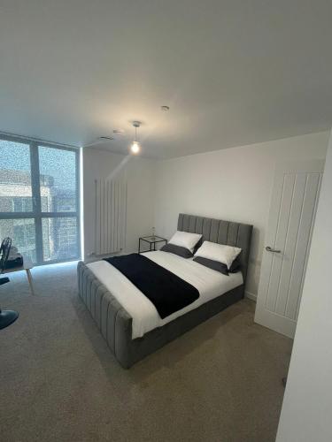 1 dormitorio con cama y ventana grande en New Luxury 2 Bedroom apartment with a beautiful London City view, en Barking