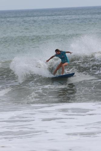Kobieta na fali na desce surfingowej w oceanie w obiekcie Hide and Seek Resort w mieście Popoyo