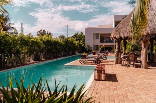 a swimming pool with tables and chairs next to a building at 78796 Cozy unit by the Pool, Fiber Optic, 70m to Ocean in Progreso
