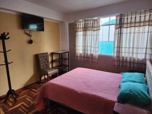 フリアカにあるHOSPEDAJE FESTEJOSのベッドルーム1室(ベッド1台、窓、椅子付)